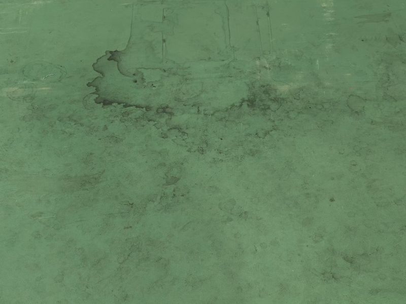 Kalarô court surface before cleaning, with grime stains and shoe marks